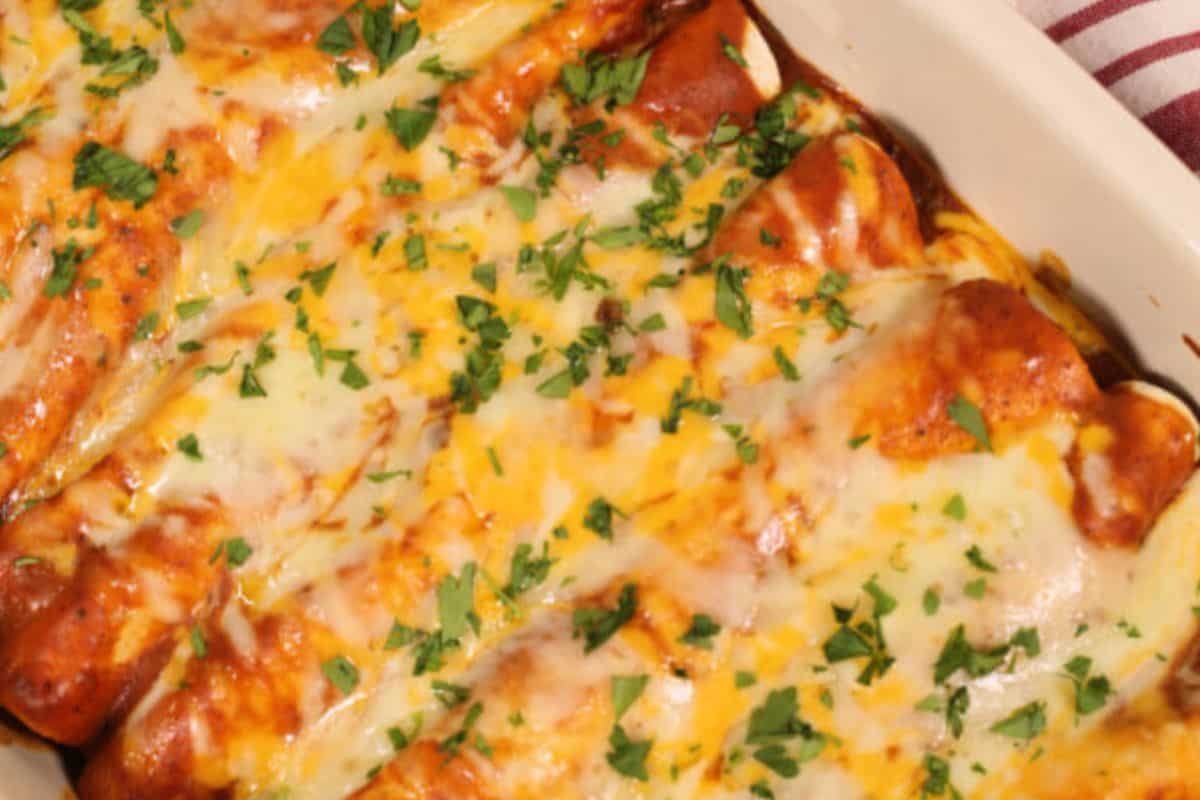 White dish of ground beef enchiladas. 