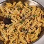 A pan of philly cheese steak pasta with fresh parsley on top.