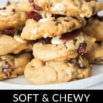 A stack of soft and chewy white chocolate cranberry cookies arranged on a white plate, with text below describing these delectable treats.