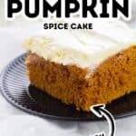 A slice of pumpkin spice cake with white frosting sits on a black plate. Text on the image reads “2 Ingredient Pumpkin Spice Cake Easy,” perfectly highlighting this simple and delicious pumpkin spice cake recipe.