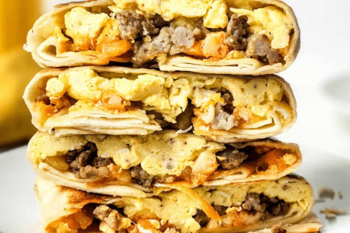 A stack of breakfast crunchwraps filled with scrambled eggs, sausage, and cheese.