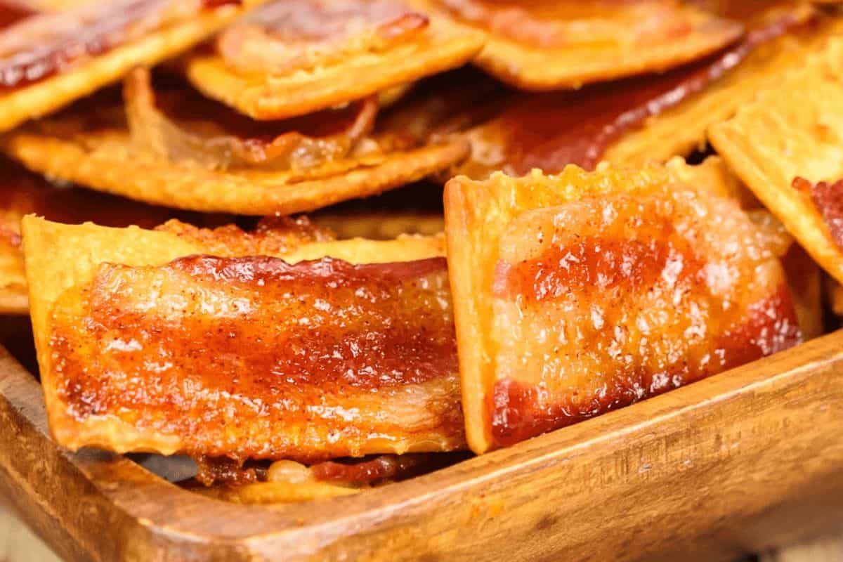 Glazed bacon crackers in a wooden dish.