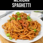 A plate of delicious Mexican spaghetti topped with savory ground meat and garnished with chopped green onions, artfully arranged on a rustic wooden board.