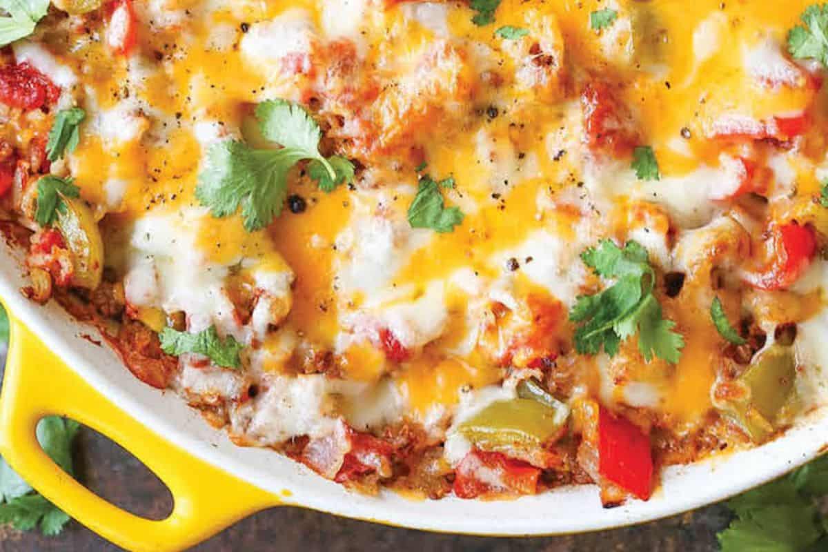 A close-up of a cheesy baked casserole with red and green bell peppers, topped with melted cheese and garnished with fresh cilantro in a yellow dish, reminiscent of Grandma's vintage casserole recipes.