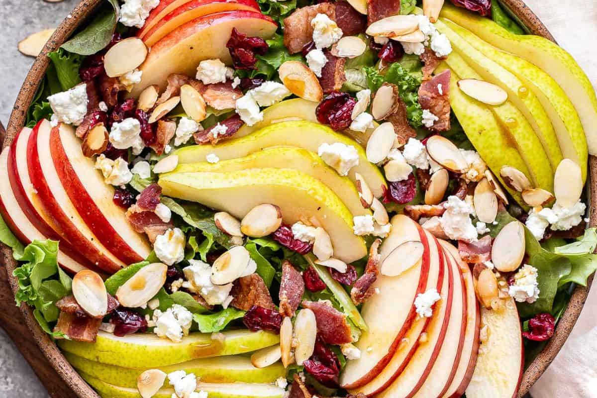 Autumn apple and pear salad in a wooden salad bowl.