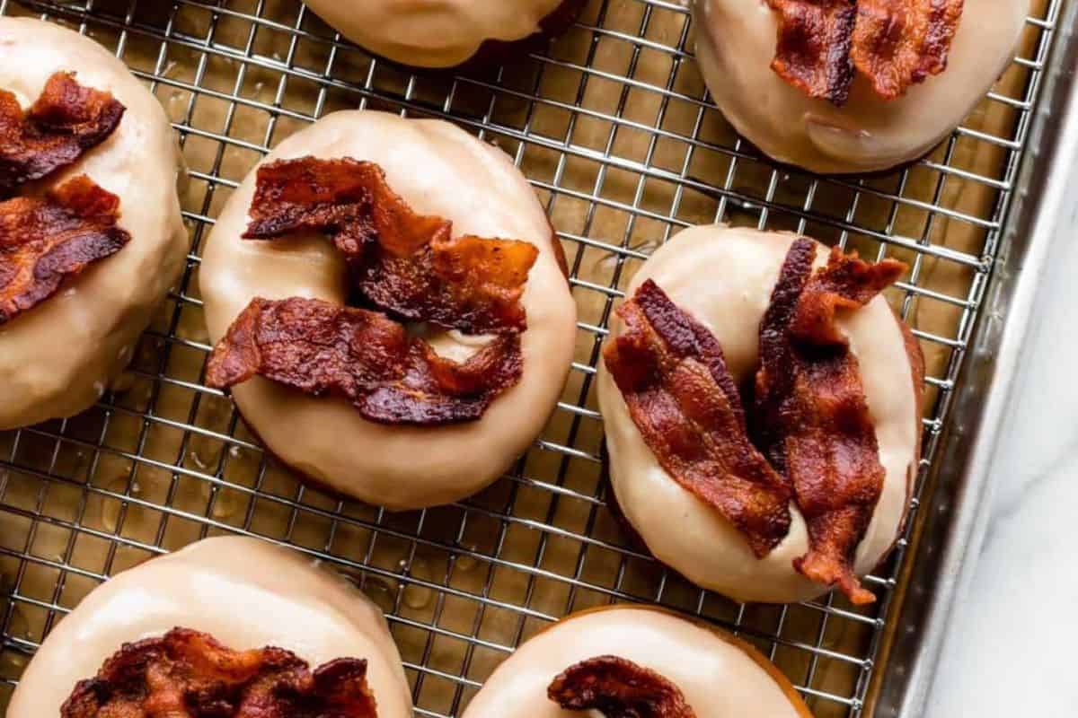 Homemade maple bacon doughnuts on a baking tray.
