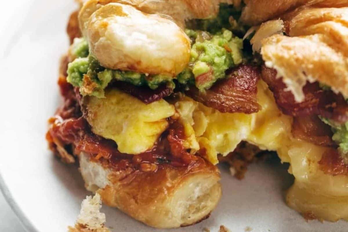 A close-up view of the ultimate breakfast sandwich on a white plate.