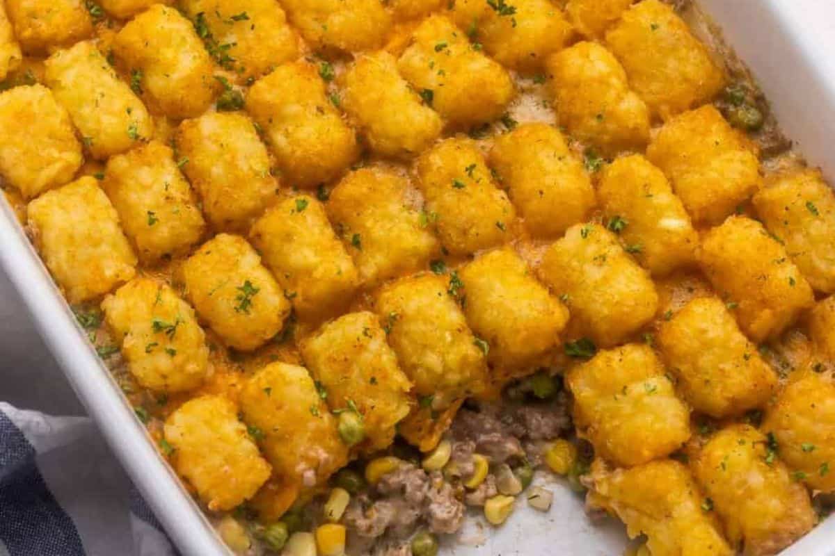 A white tray of Cheesy Tater Tot Casserole.