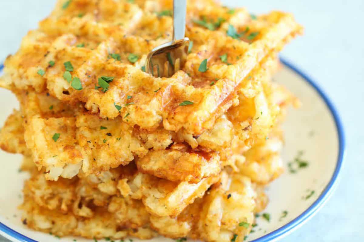 A stack of Tater Tot Waffles on a white plate.