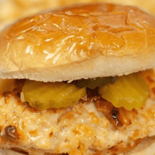 Close-up of a chicken sandwich with pickles on a bun, reminiscent of secret Chick-fil-A recipes you can make at home.