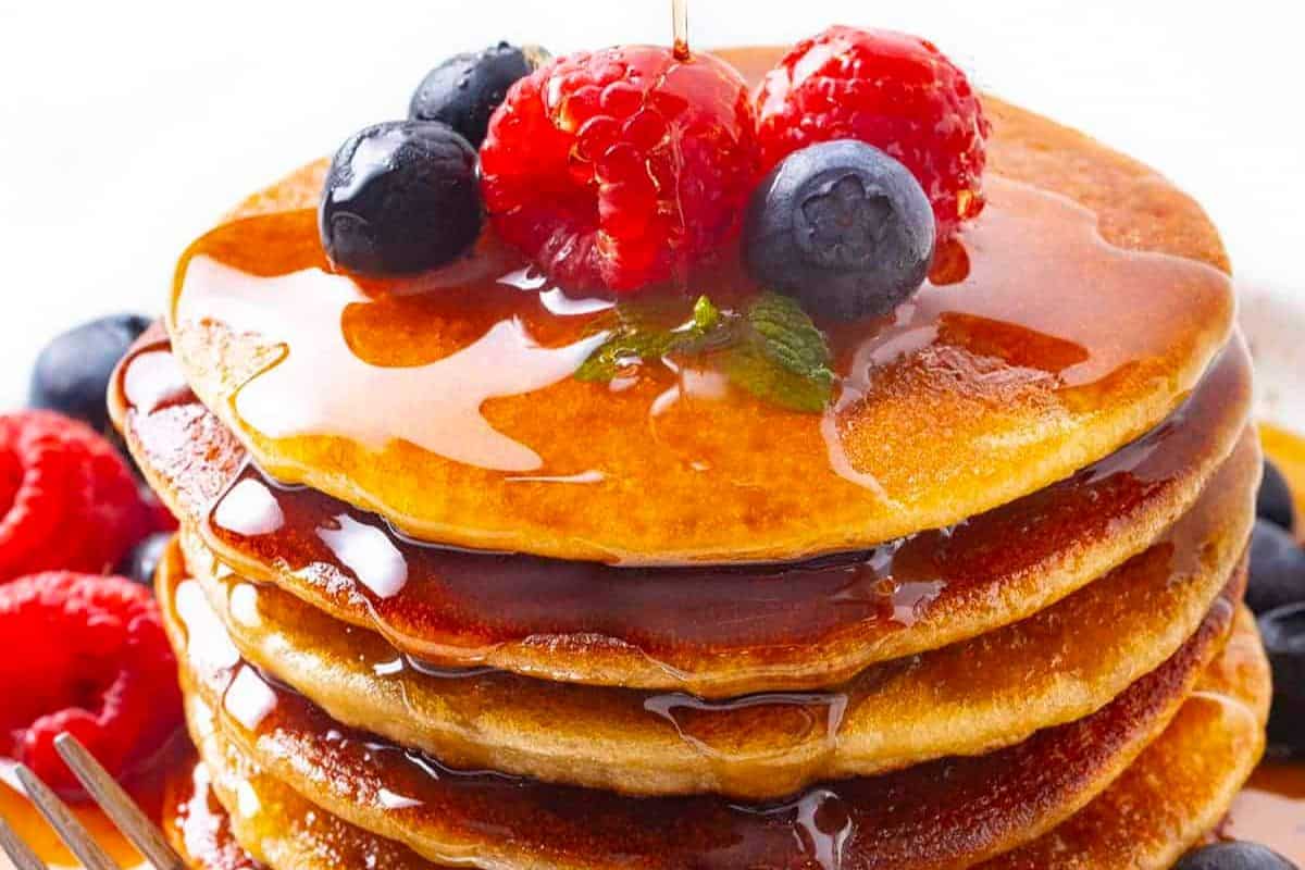 A delicious weekend breakfast treat, this stack of pancakes is adorned with fresh raspberries, blueberries, and a drizzle of syrup. Make every weekend special with mouthwatering pancake recipes that delight both your taste buds and morning routine.