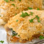 Close-up of Chicken Rollatini, elegantly garnished with chopped parsley on a clear glass dish.