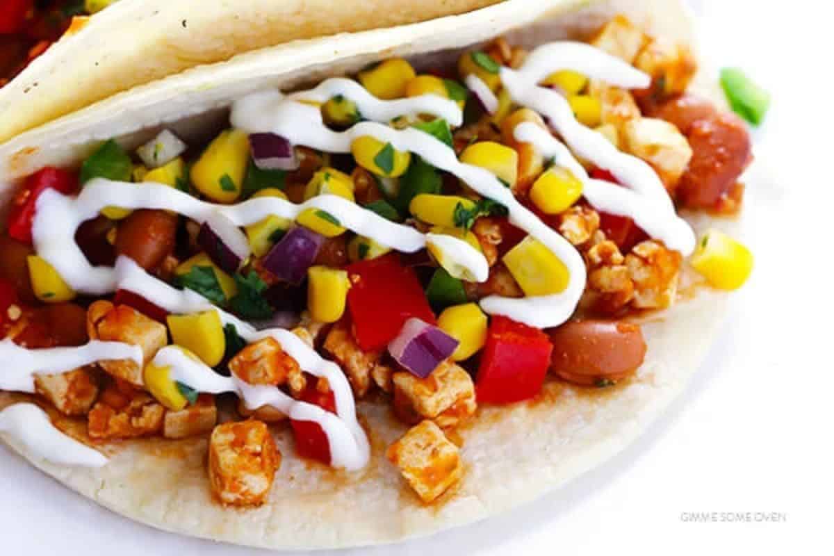 Indulge in a taco that's the real thing with diced chicken, corn, red onion, tomato, beans, and cilantro. Topped with a sour cream drizzle on a soft tortilla, it's perfect for those who crave copycat Chipotle recipes.