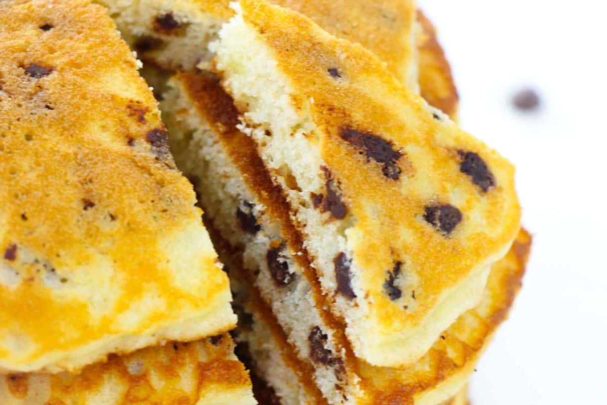 A weekend treat, this stack of chocolate chip pancakes boasts visible chips and golden brown edges. Perfect for those who love to make indulgent pancake recipes on leisurely mornings.