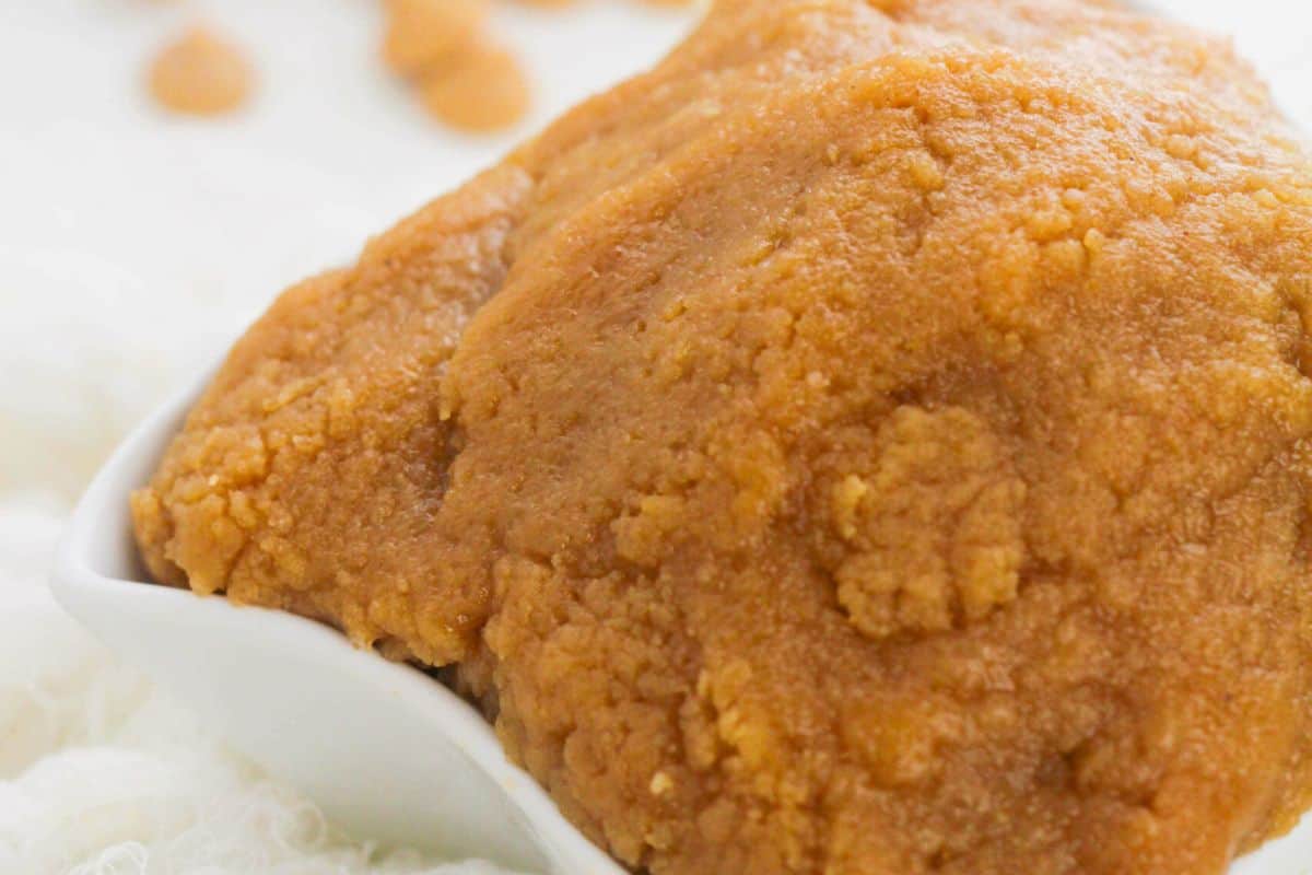A close-up of a dish filled with a large, crumbly, brown mass, possibly a type of dough or food paste, placed on a white surface. This must-try concoction could be the next star in your peanut butter recipes collection.