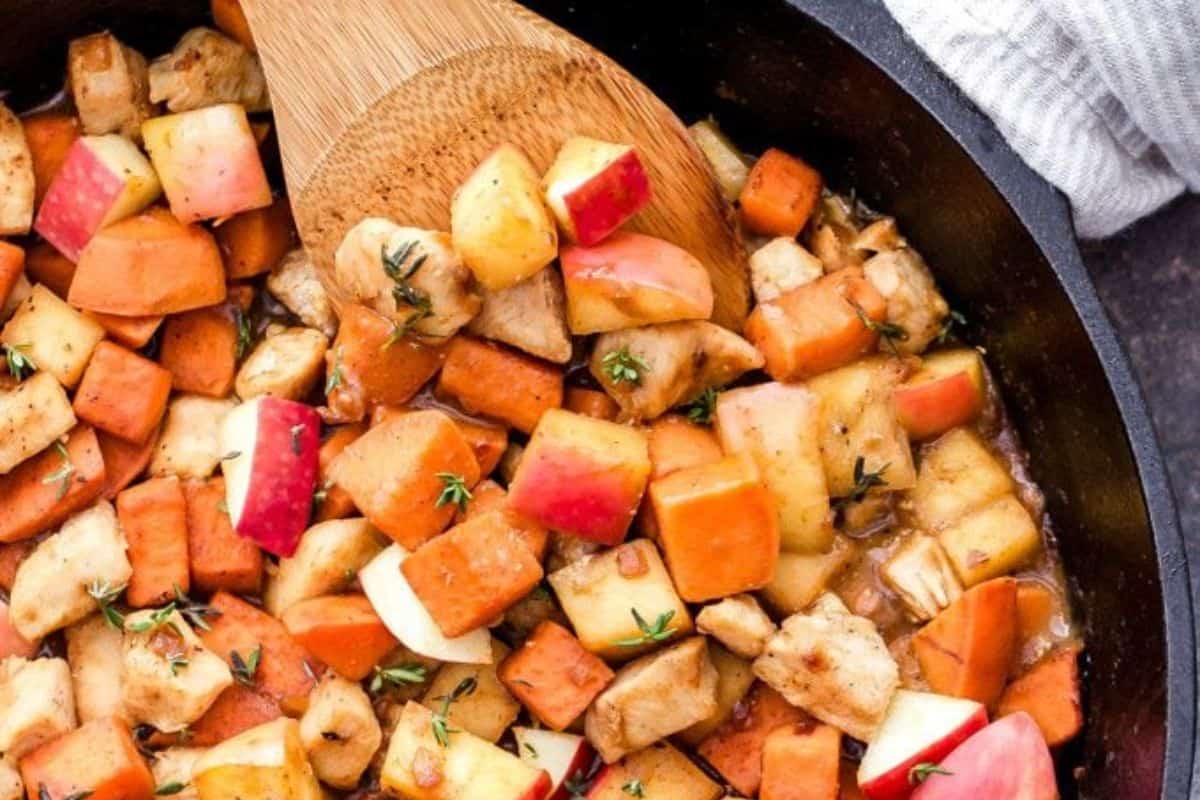A skillet filled with diced sweet potatoes, apples, and chicken, garnished with fresh thyme, makes one of the most comforting recipes—perfect for cozy autumn dinners and Fall meals.