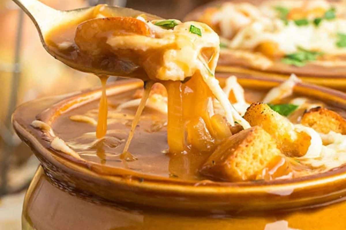 Close-up of a bowl of french inion soup, garnished with cheese and croutons.
