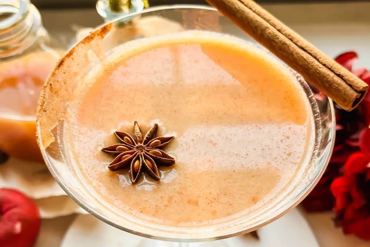 A creamy spiced drink in a martini glass, garnished with a star anise and a cinnamon stick—perfect for those who love Autumn cocktails.