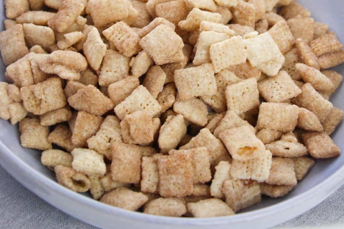 A close-up of a bowl filled with churro chex mix muddy buddies.