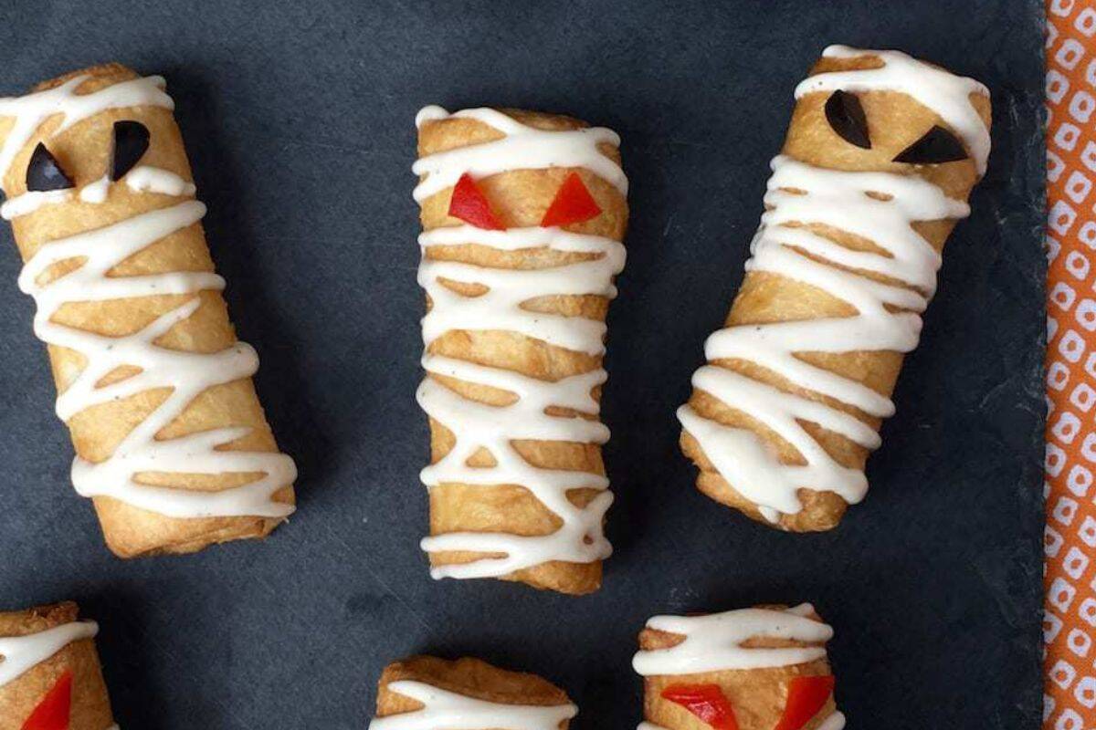 Crescent rolls wrapped around cheesy pizza filling, shaped and baked to look like mummy snacks.
