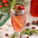 A closeup on the cranberry mimosa decorated with berries.