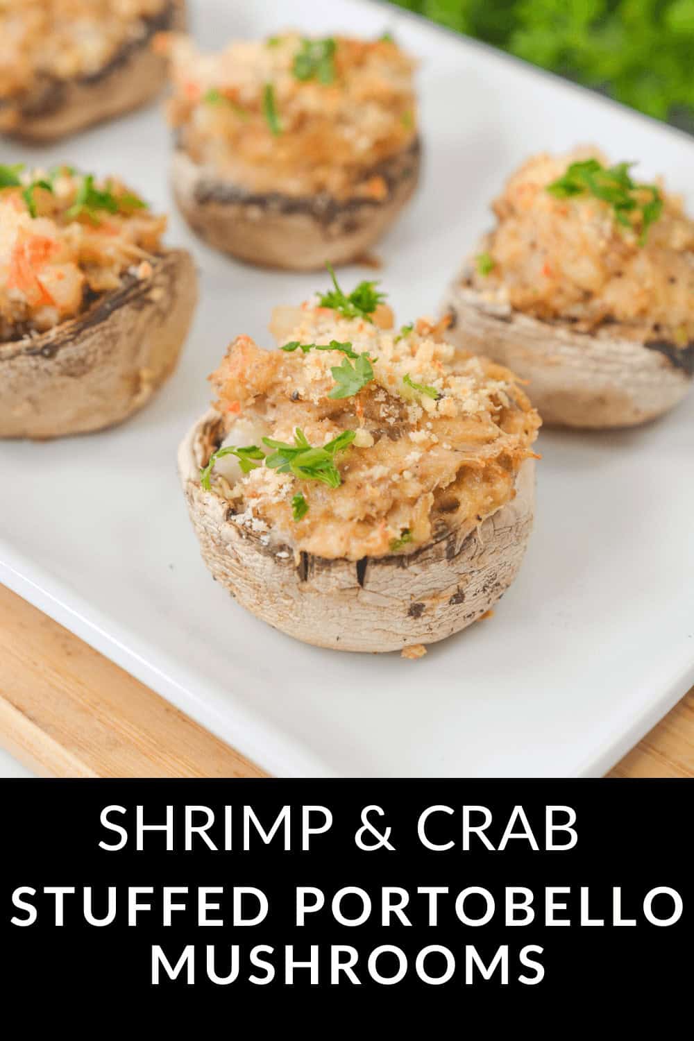 A plate showcasing crab stuffed portobello mushrooms, brimming with shrimp and garnished with fresh herbs.