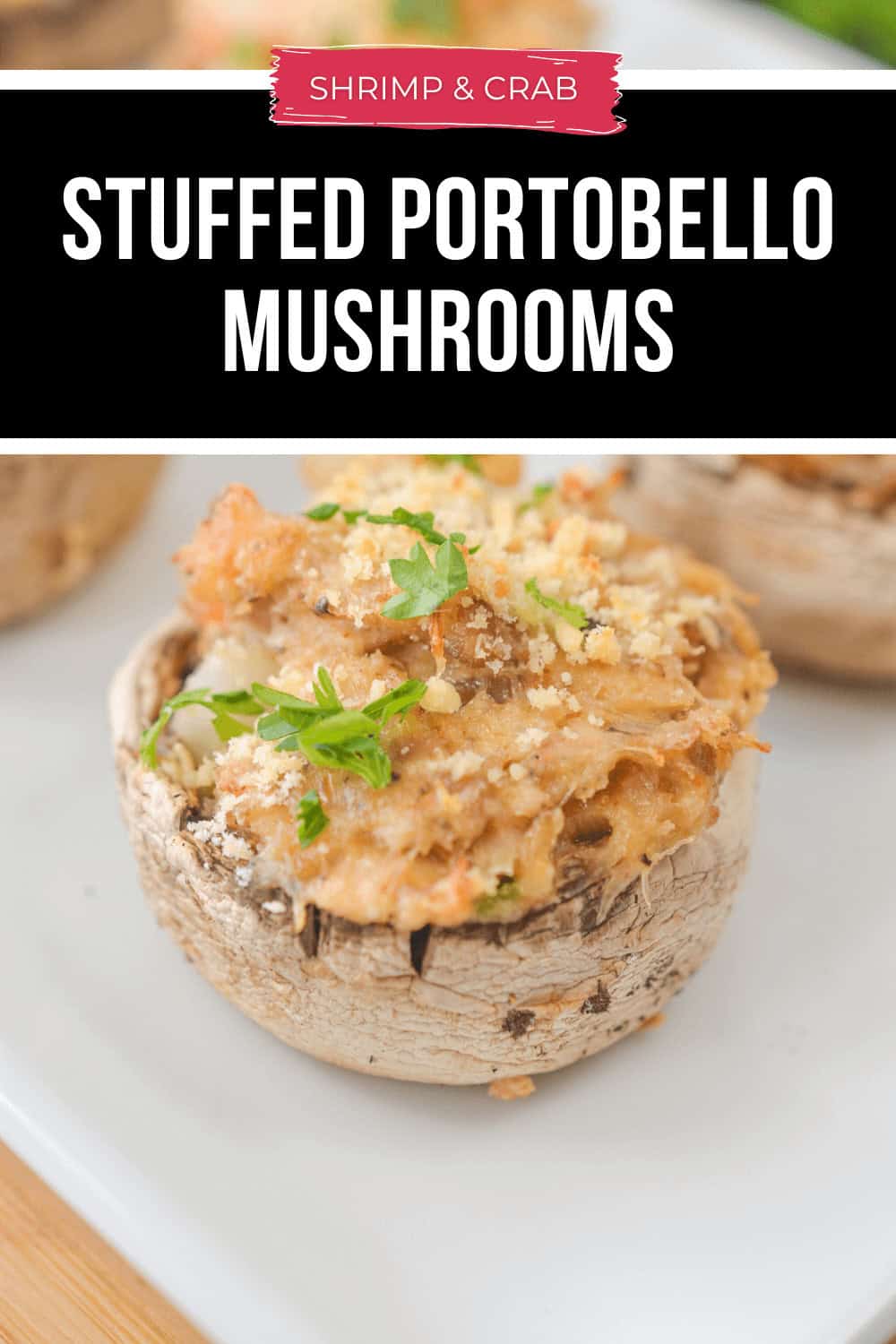 A crab-stuffed portobello mushroom crowned with breadcrumbs and garnished with parsley sits elegantly on a white plate.