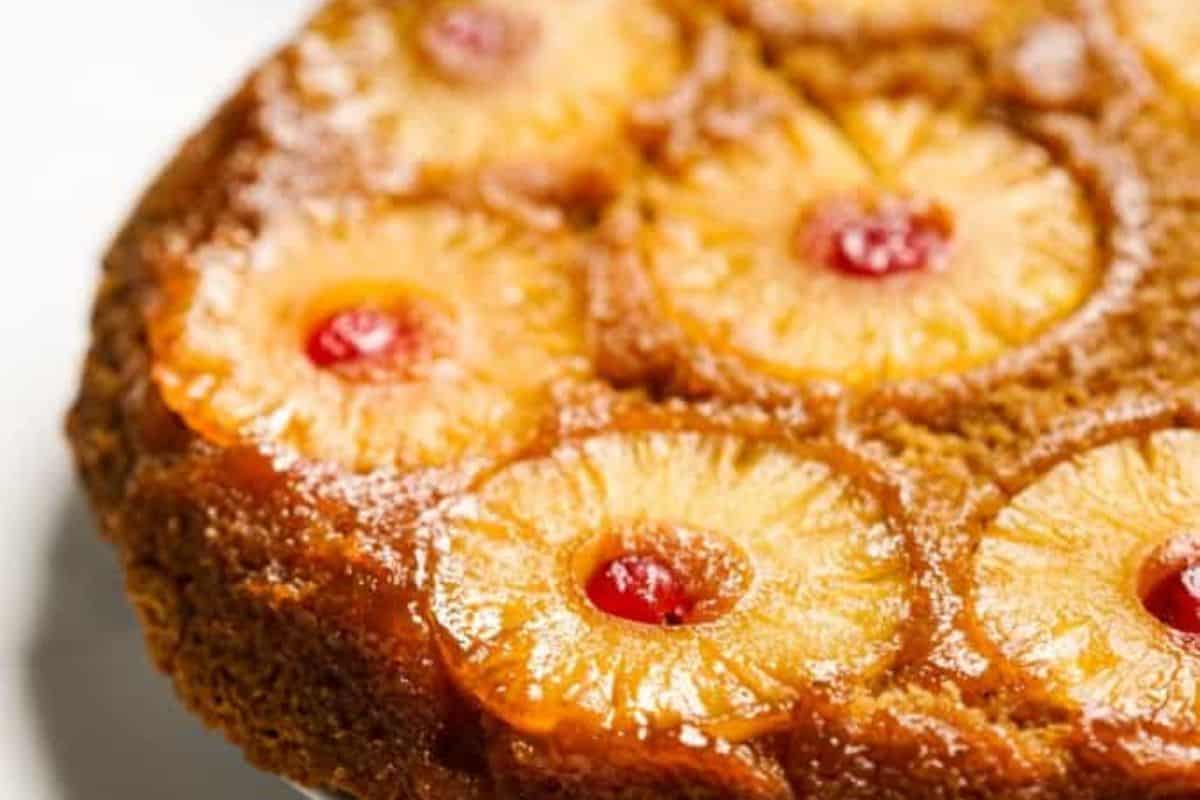 A close-up of a pineapple upside-down cake topped with pineapple rings and cherries—one of those cast iron recipes that's perfect for any occasion.