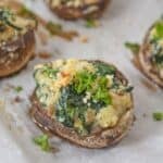 An appetizer topped with breadcrumbs and fresh parsley, arranged on a sheet of parchment paper.