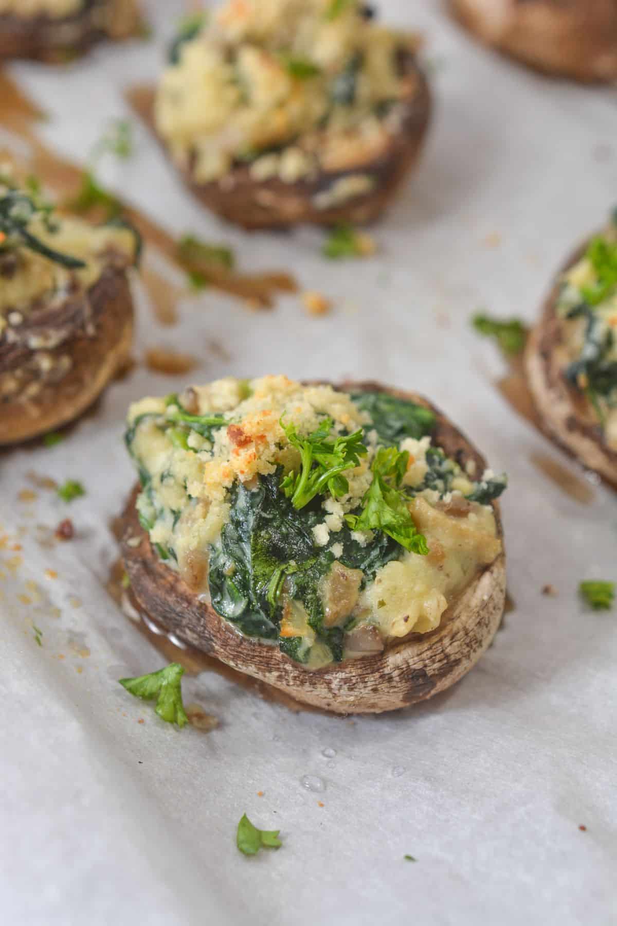 An appetizer topped with breadcrumbs and fresh parsley, arranged on a sheet of parchment paper.