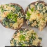 Three stuffed mushrooms filled with a savory blend of spinach and Boursin cheese are displayed on a white plate, garnished with fresh herbs. Text on the image invites viewers to comment “recipe” for details.