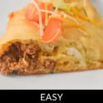 A slice of Taco Crescent Ring is artfully topped with tomato, cheese, and lettuce on a pristine white plate.