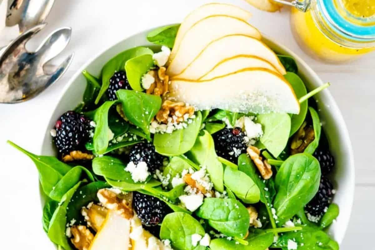 Winter salad with meyer lemon vinaigrette in a white bowl.