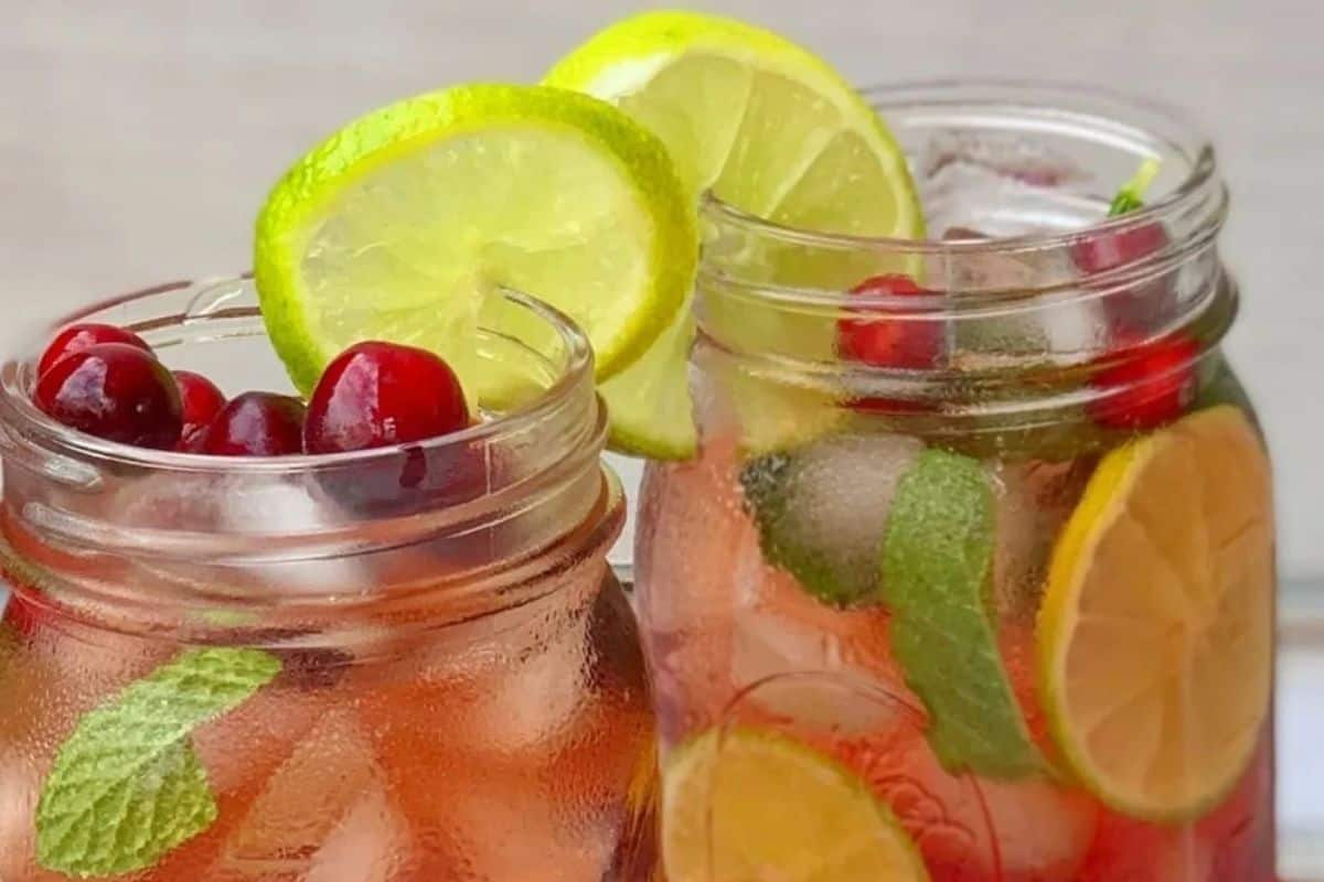 Two mason jars of mint cranberry mojito.