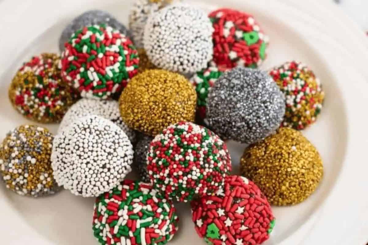 Chocolate brownie balls covered in sprinkles and holiday-themed candy coatings.