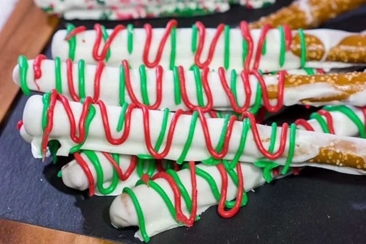 Pretzel rods dipped in chocolate and coated with red and green icing drizzles.