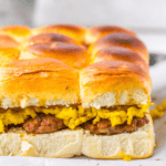 A close-up of delicious sandwicb showcases sandwiches filled with scrambled eggs and sausage, artfully arranged on parchment paper.