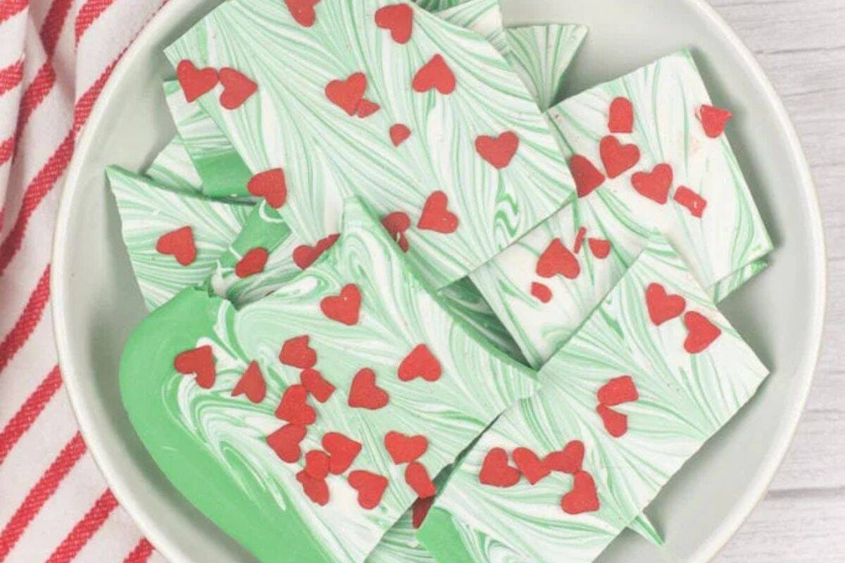 Sheets of green chocolate bark broken into pieces, with red hearts and festive sprinkles on top.