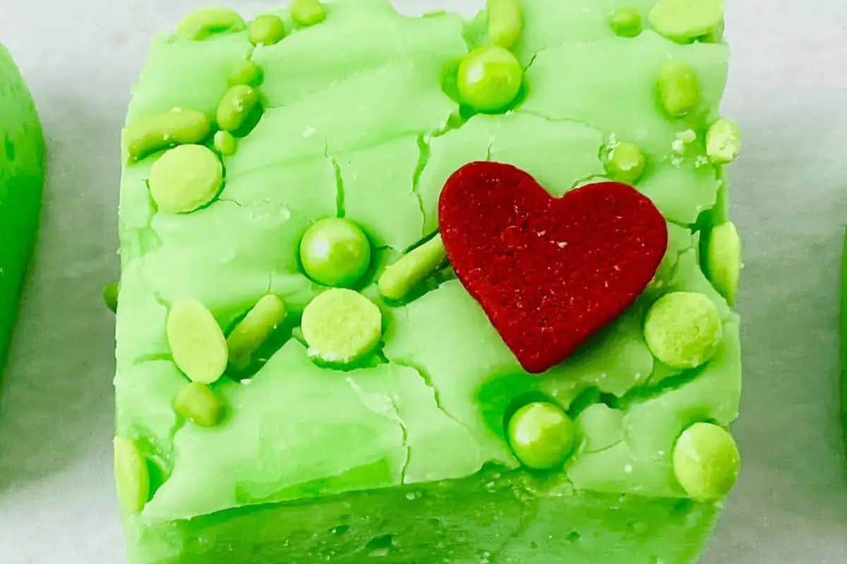 Bright green squares of fudge topped with a single red heart sprinkle.
