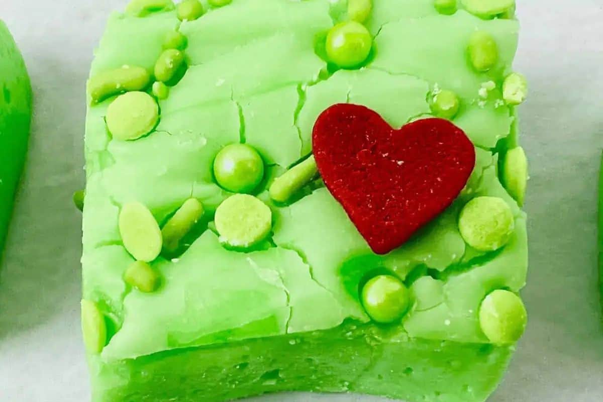 Bright green fudge squares topped with a red heart candy, inspired by the Grinch.