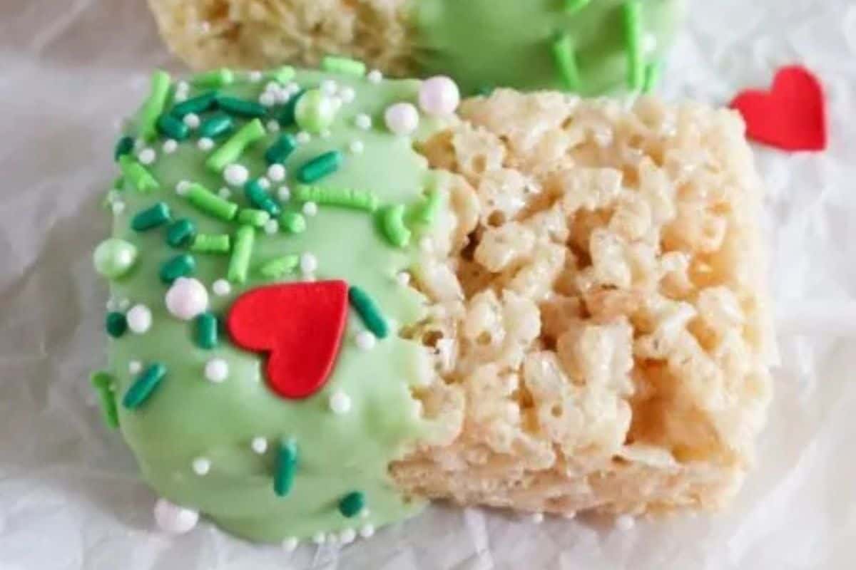 Rice Krispie treats dipped in green chocolate and coated with sprinkles and a red candy heart.