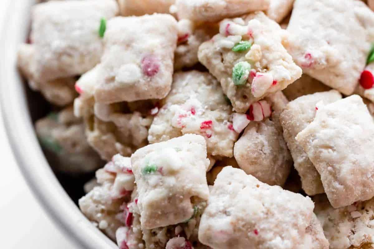 White chocolate-covered snack mix coated in powdered sugar and crushed peppermint.