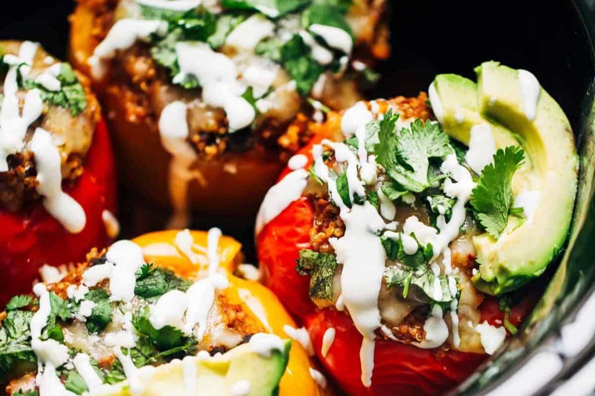 Close-up of easy stuffed peppers topped with melted cheese, cilantro, avocado slices, and a drizzle of white sauce—perfect for quick weeknight dinners.