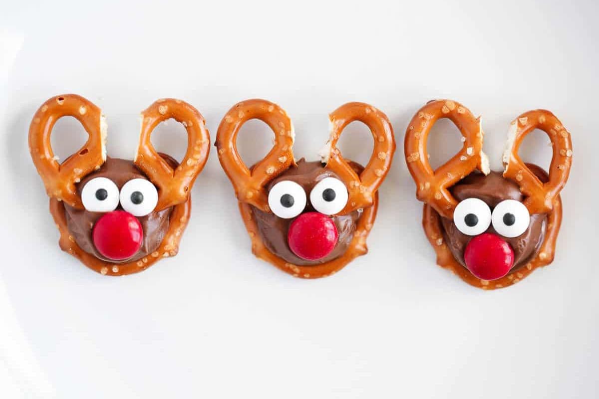 Mini reindeer treats made from pretzels, Rolos, candy eyes, and red M&M noses.