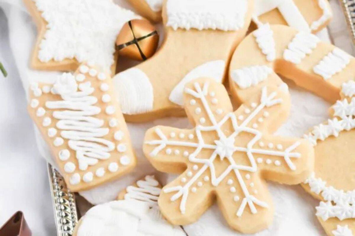 Buttery shortbread cookies decorated with white icing on a silver serving platter.