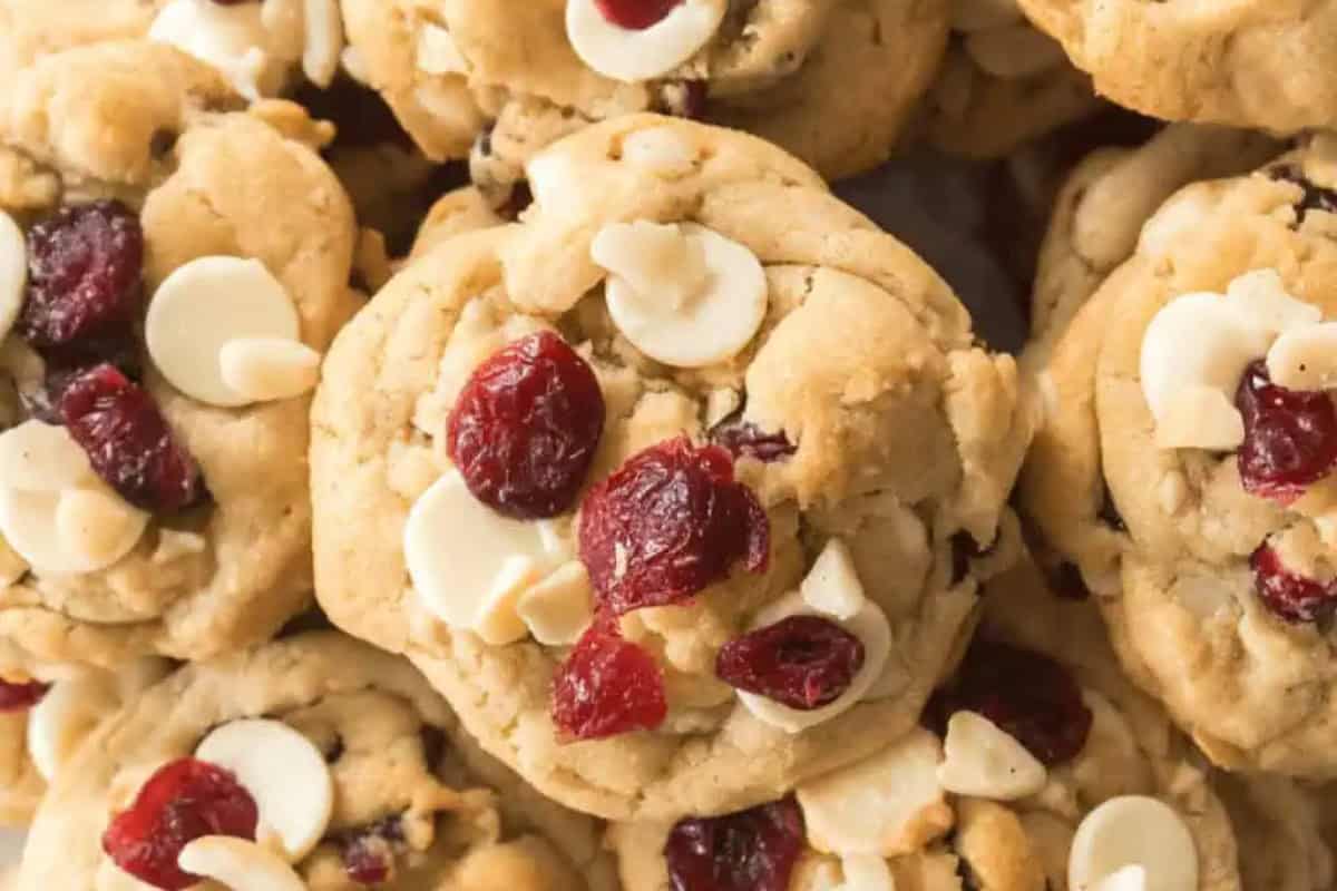 Close-up view of Christmas cookies with white chocolate chips and dried cranberries clustered together.