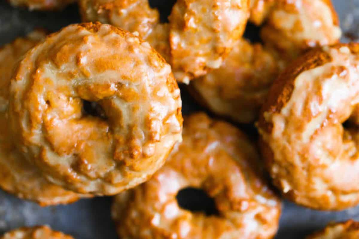 A close-up view of several glazed donuts arranged closely together, showcasing their shiny, textured surfaces—perfect pumpkin desserts to savor those cozy fall vibes.