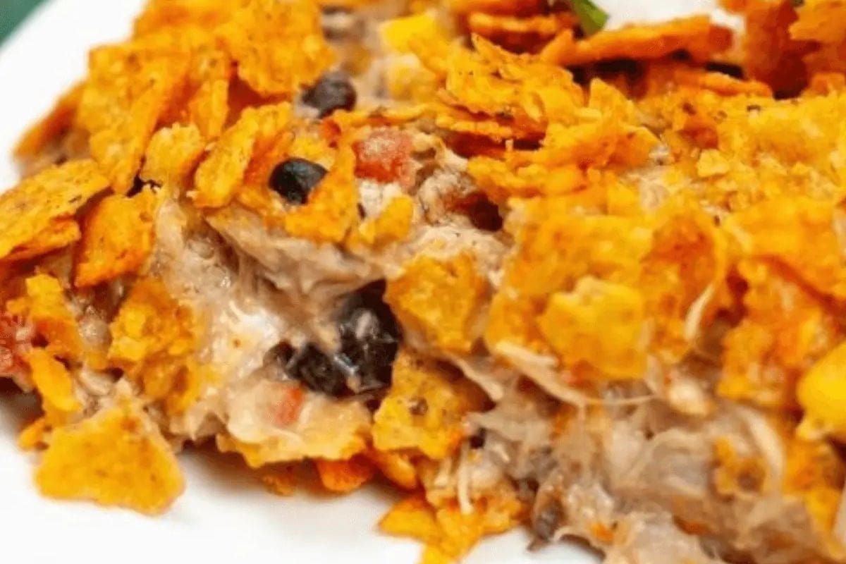 A close-up of a casserole topped with crumbled tortilla chips, featuring visible black beans and a creamy filling—perfect for cooler weather and those seeking comforting casserole recipes.