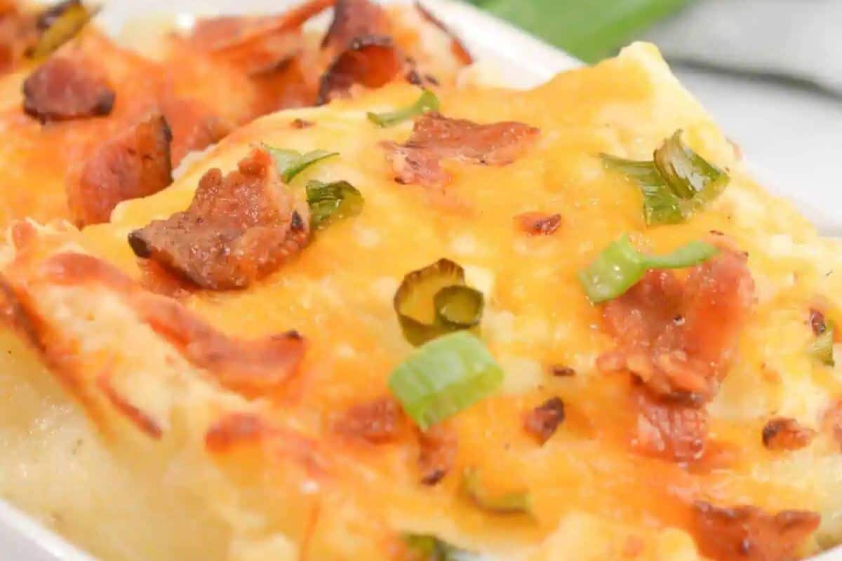 Close-up of a baked casserole topped with melted cheese, bacon pieces, and chopped green onions—a perfect dish for cooler weather and a must-try for fans of good casserole recipes.