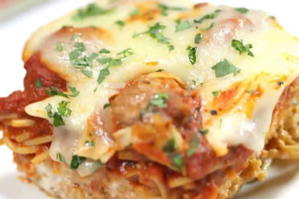 A close-up of a baked lasagna slice topped with melted cheese, tomato sauce, and chopped parsley—perfect for cooler weather and a must-try for anyone seeking good casserole recipes.